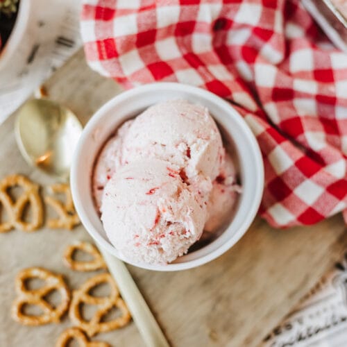 No churn strawberry cottage cheese ice cream in a white bowl on a wooden cutting board.