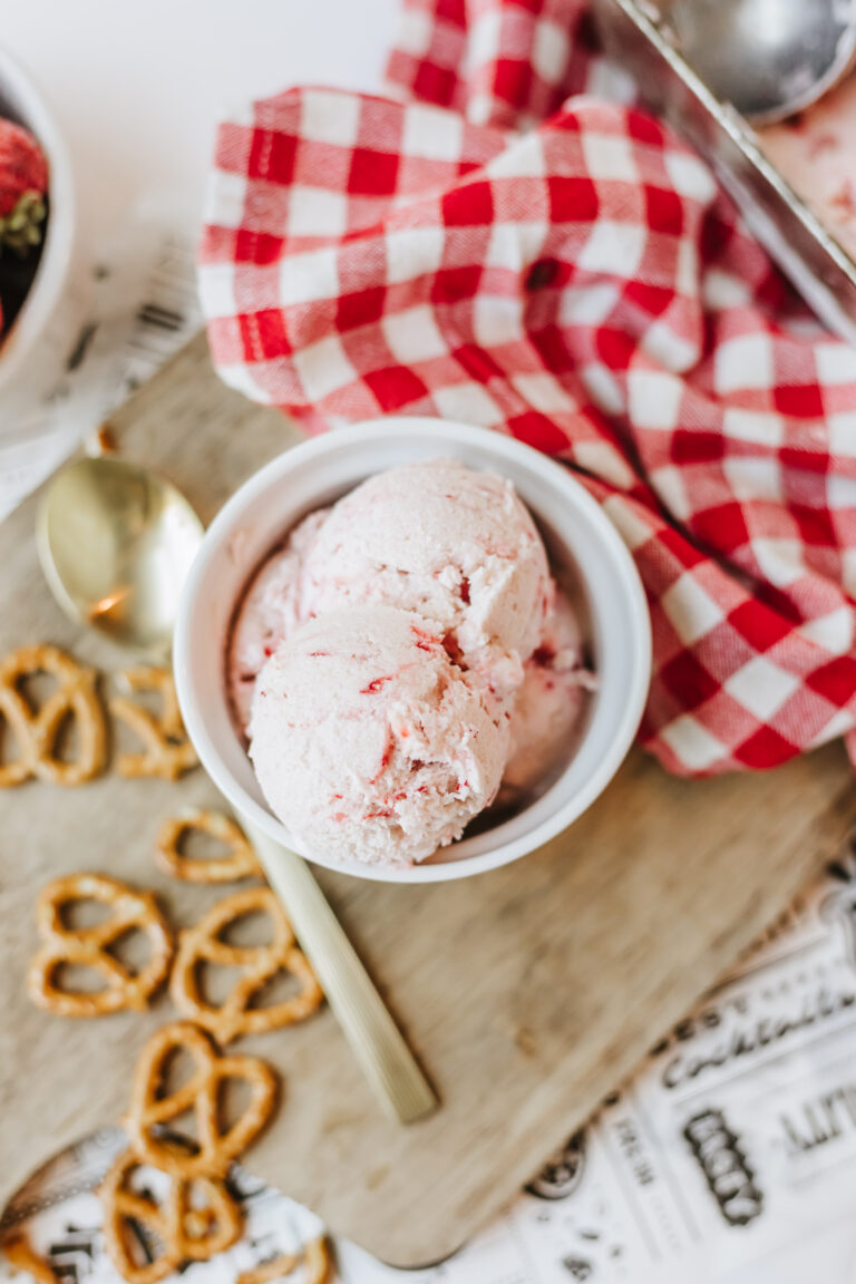 No churn strawberry cottage cheese ice cream in a white bowl on a wooden cutting board.