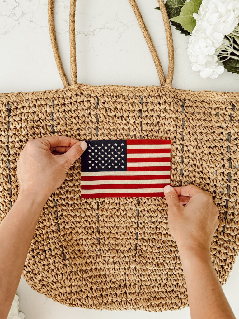Position the small American flag where you want to adhere it on the hanging bag.