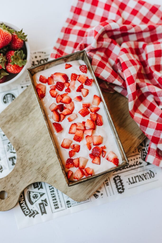 The second layer of the strawberry ice cream added to the metal loaf pan.
