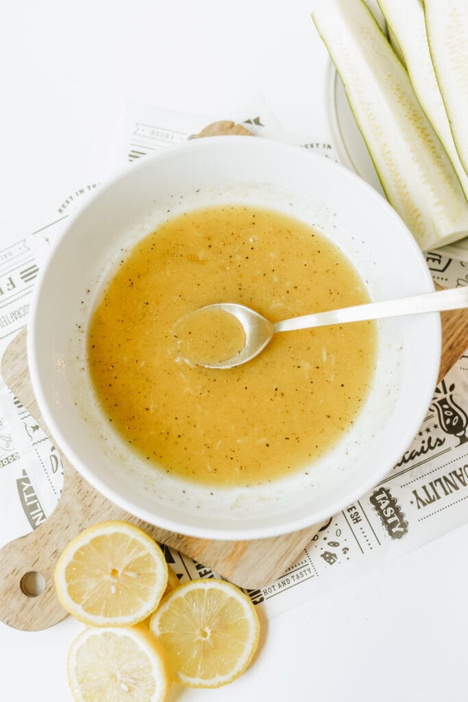 Using a spoon or a whisk combine marinade ingredients together before adding the zucchini spears.