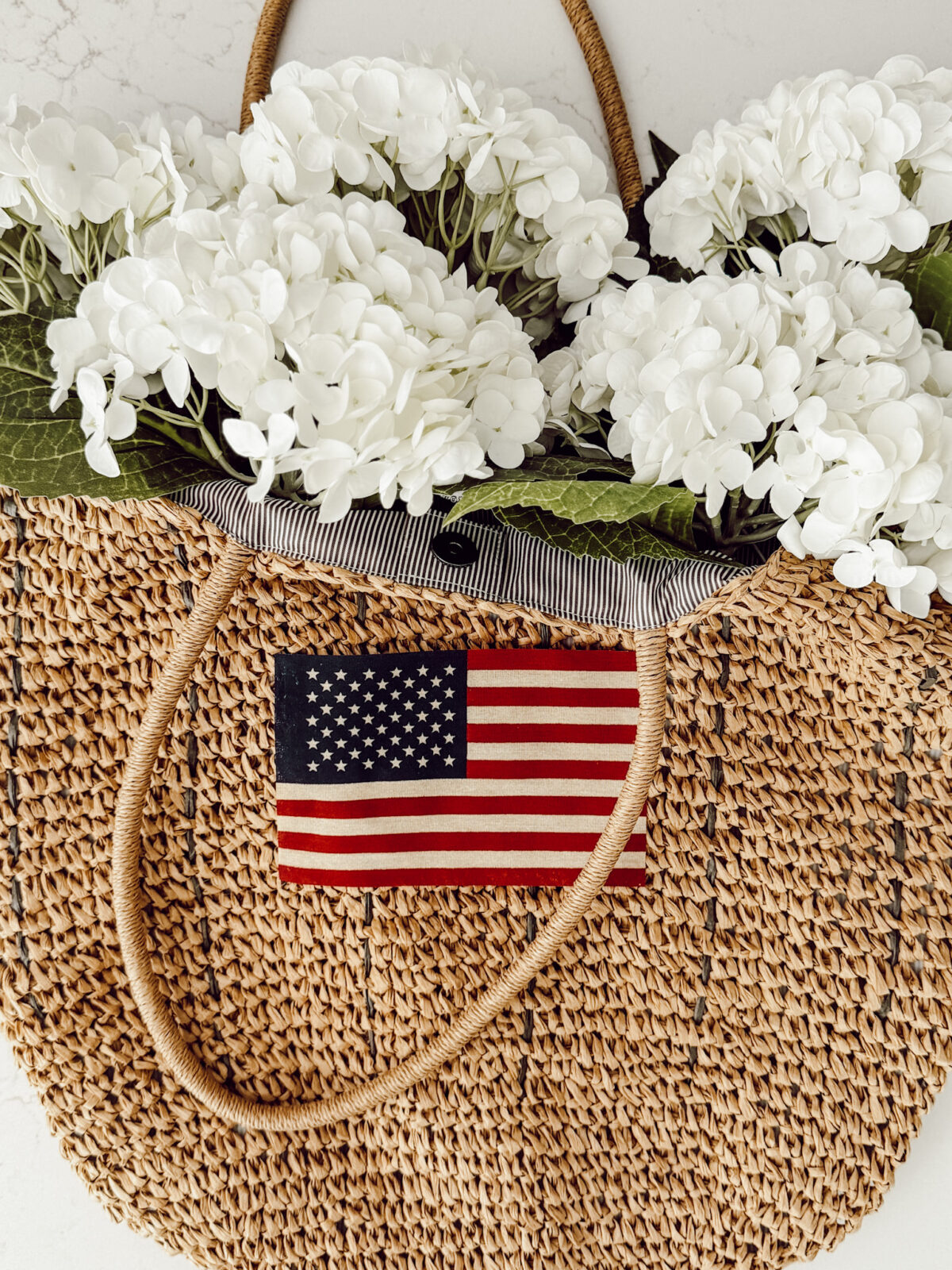 Fill your DIY Patriotic hanging door basket with faux white hydrangeas for a classic Americana look.