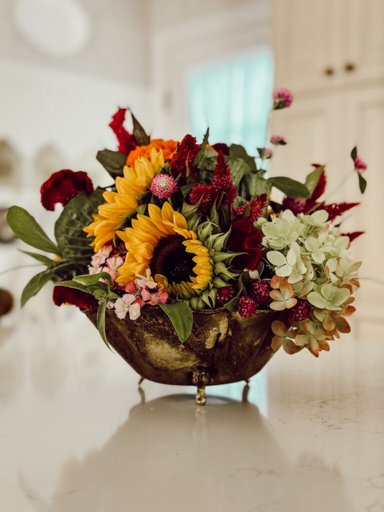 Colorful fall flowers in a vintage brass bowl is an easy fall flower arrangement idea.