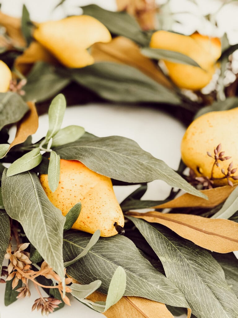 Fall decorations with faux pears on a wreath.