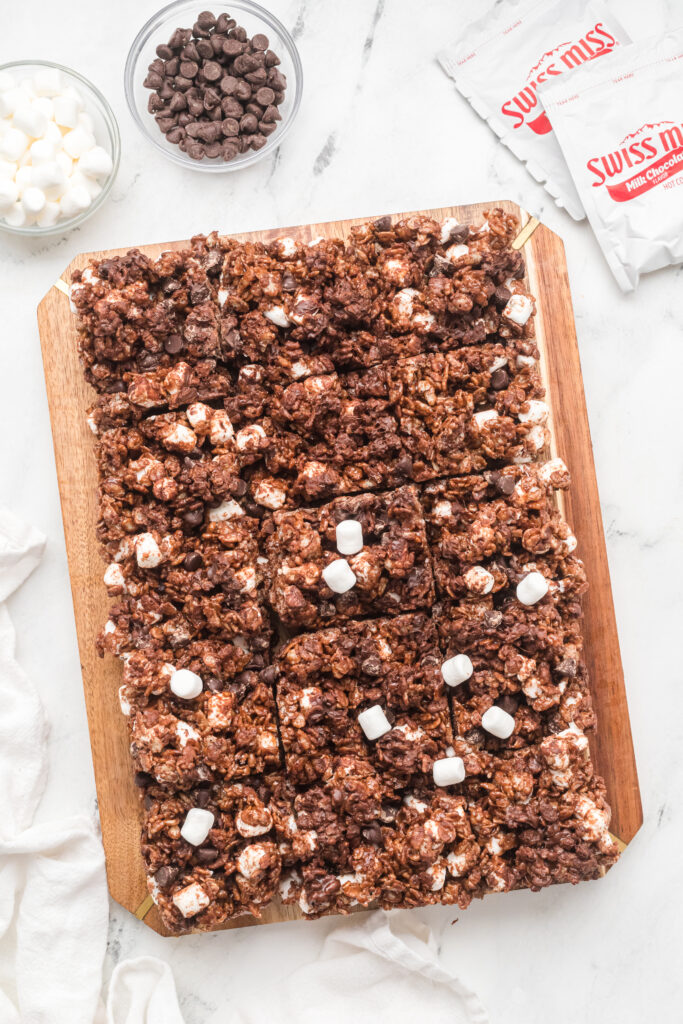 Chocolate Rice Krispie treats on a wooden cutting board.