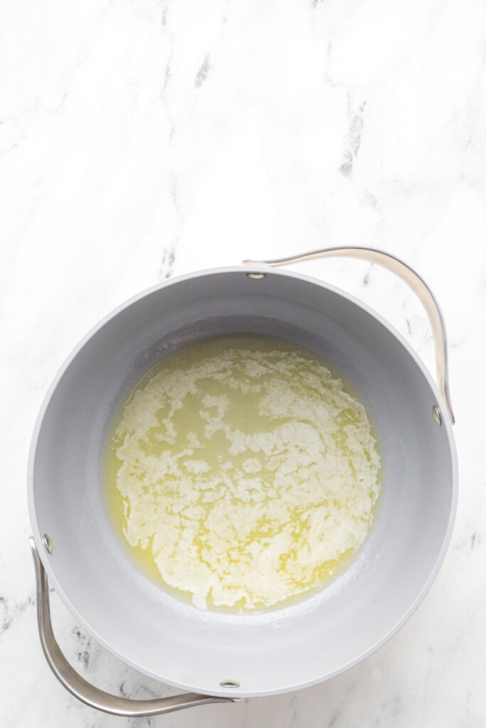 Melted unsalted butter in a large pot for the Rice Krispie treats cereal base.