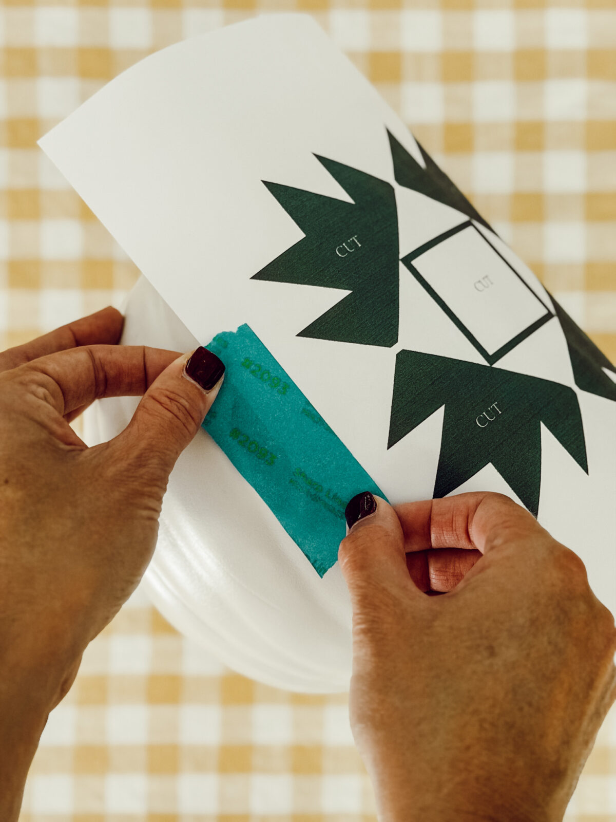 Use painter's tape to attach the quilt pattern onto the pumpkin.