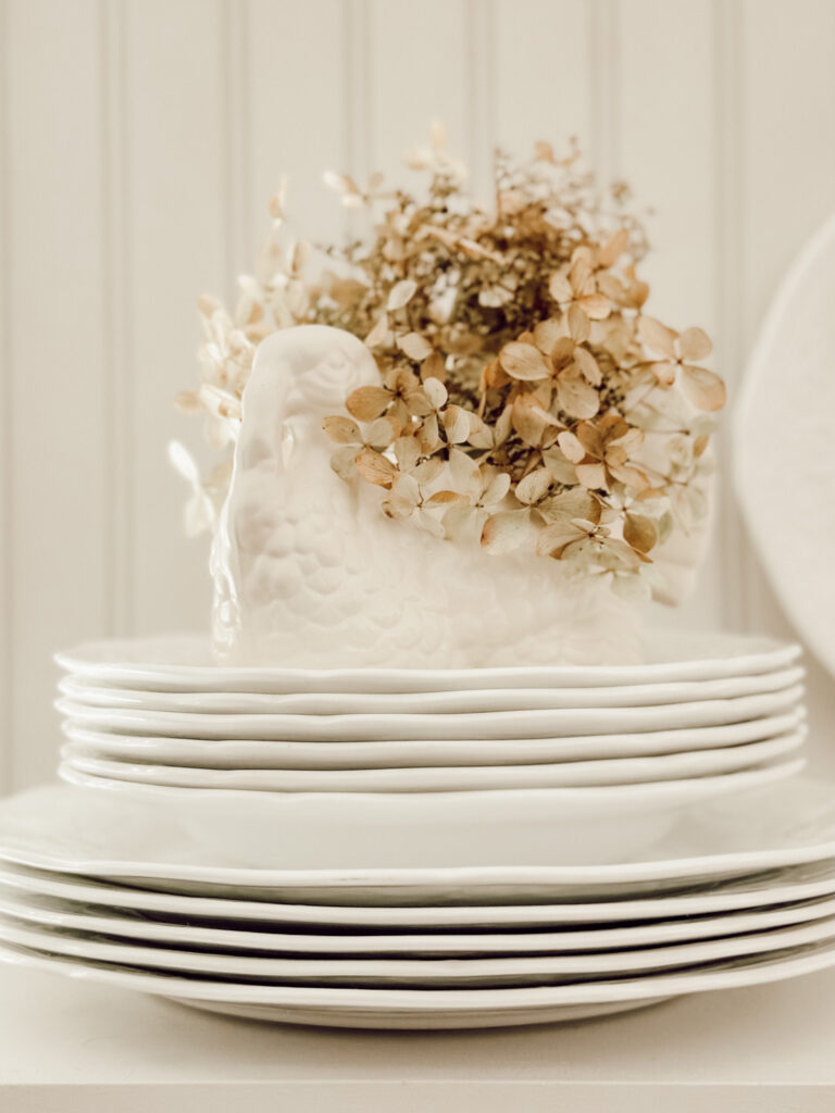 Dried brown hydrangea blooms in a vintage turkey planter for easy fall decor.