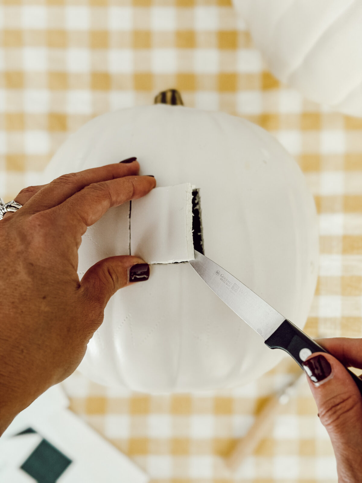 Use a small paring knife to cut out the quilt shapes from the pumpkin.